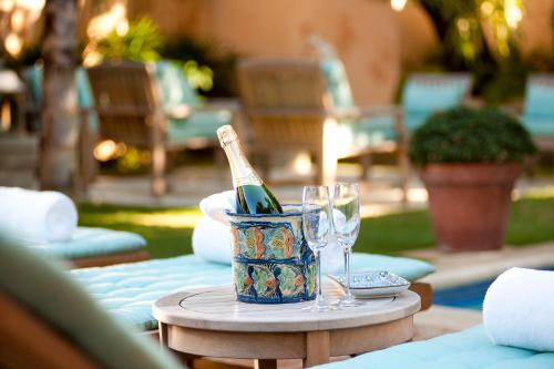a bottle of wine sitting on a table with glasses at Casas del XVI in Santo Domingo