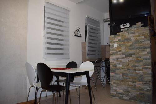 a dining room with a table and chairs and a brick wall at Apartment FINI in Tivat