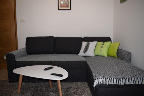 a living room with a black couch and a white table at Apartment FINI in Tivat