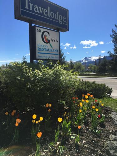 a sign and flowers in front of a sign at Travelodge by Wyndham Juneau in Mendenhaven