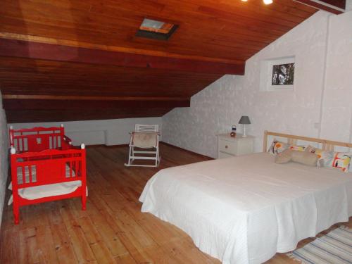 a bedroom with a white bed and a wooden ceiling at Quinta da Mesa in Macinhata do Vouga