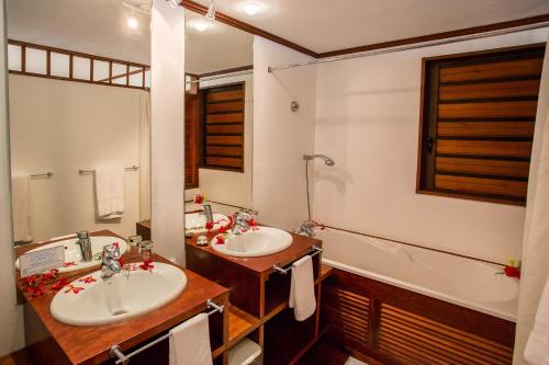 a bathroom with two sinks and a tub at Oure Lodge Beach Resort in Vao