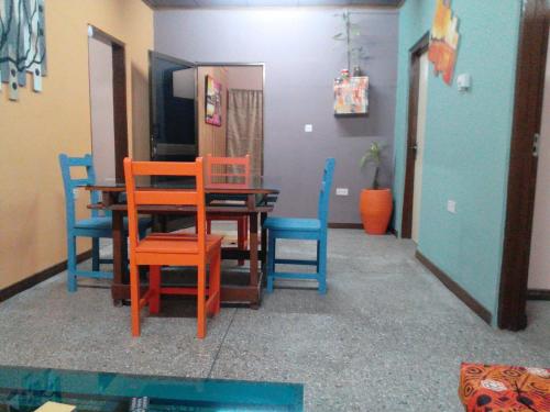 a dining room with colorful chairs and a table at Feehi's Place in Accra