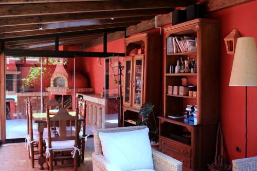 サン・クリストバル・デ・ラ・ラグーナにあるLuxury house in the heart of Tenerifeの赤い壁のダイニングルーム(テーブル、椅子付)