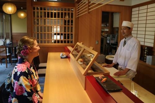 a man and a woman standing at a counter in a kitchen at Ryokan Yamazaki in Kyoto