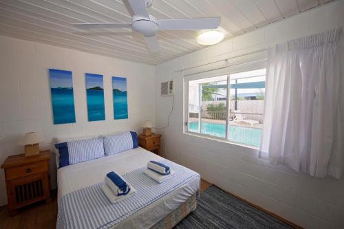 Un dormitorio con una cama y una ventana con piscina. en Apollo Jewel Beachfront Apartments, en South Mission Beach