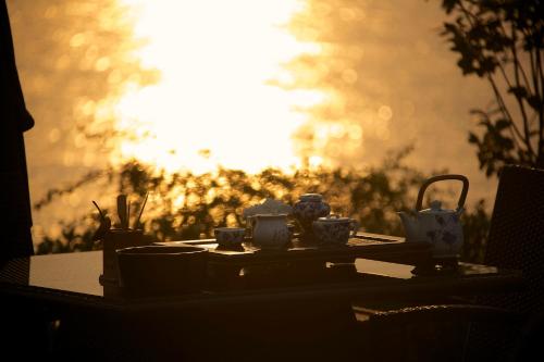 a table with cups and tea sets on it at Zhejiang Xizi Hotel in Hangzhou