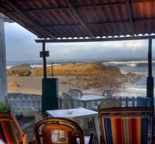 a table and chairs with a view of the beach at Playa Roca Beach Hotel in Las Peñitas