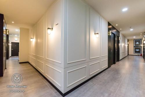 a hallway of a building with white walls at Hotel Marcher in Busan