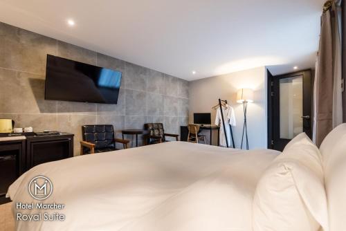 a hotel room with a bed and a tv at Hotel Marcher in Busan