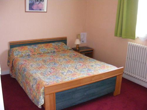 1 dormitorio con 1 cama con un edredón colorido en Hotel du Commerce, en Challans