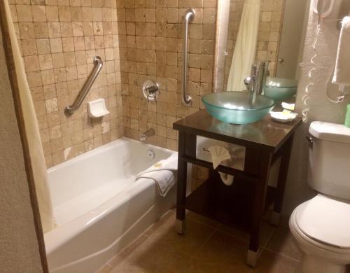 uma casa de banho com uma banheira, um lavatório e um WC. em Cannery Row Inn em Monterey