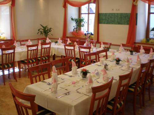 una habitación con mesas y sillas con servilletas rosas. en Gästehaus Freitag das kleine Hotel en Sankt Georgen