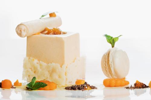 a cake with a roll and fruit on a table at Kongress Hotel Davos in Davos