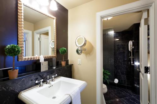 een badkamer met een wastafel en een spiegel bij Hotel Mazarin in New Orleans