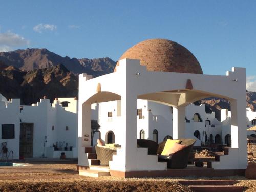 a building with a gazebo with mountains in the background at Daniela Diving Resort Dahab in Dahab
