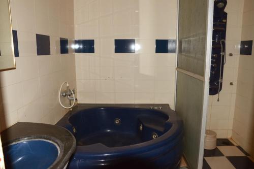 Habitación con baño con bañera azul. en Strawberry Country, en Mahabaleshwar