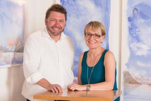 a man and a woman standing in front of a painting at Hotel Gerig in Wassen
