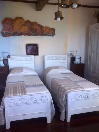 two beds in a room with white furniture at B&B Terre e Colori in Sant'Olcese