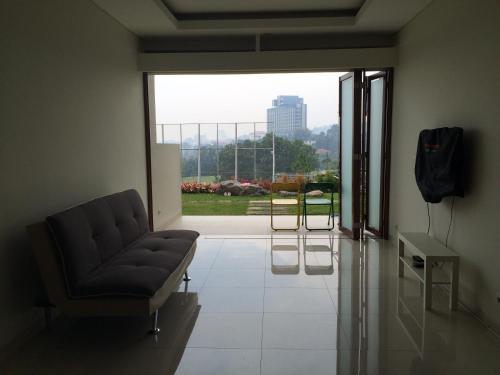 a living room with a couch and a large window at Roemah Asri Villa - Resor Dago Pakar in Bandung