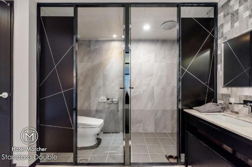 a bathroom with a shower with a toilet and a sink at Hotel Marcher in Busan