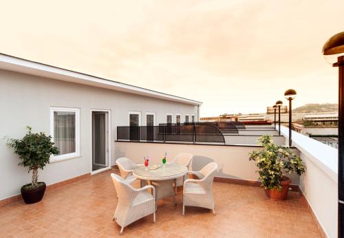 a patio with a table and chairs on a balcony at Hotel Tiempo in Naples