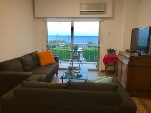 a living room with a couch and a flat screen tv at Sea View Apartment in Limassol