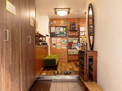 a living room filled with furniture and a book shelf at J-Hoppers Hiroshima Guesthouse in Hiroshima
