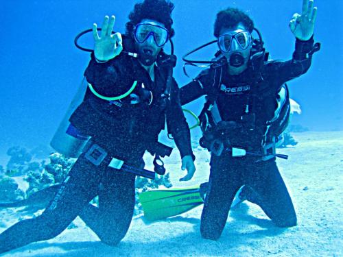duas pessoas no oceano com as mãos no ar em Daniela Diving Resort Dahab em Dahab