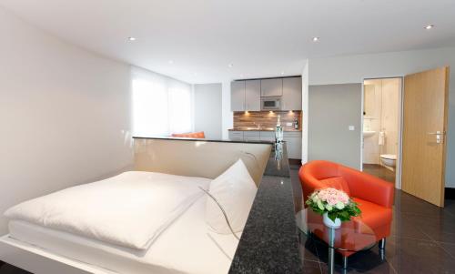 a living room with a white couch and a red chair at Appartements am Kleeblatt in Wuppertal