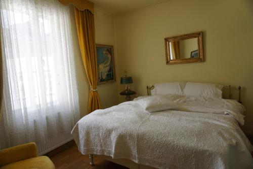 a bedroom with a white bed and a window at Apartment at Mozart-Geburtshaus in Salzburg