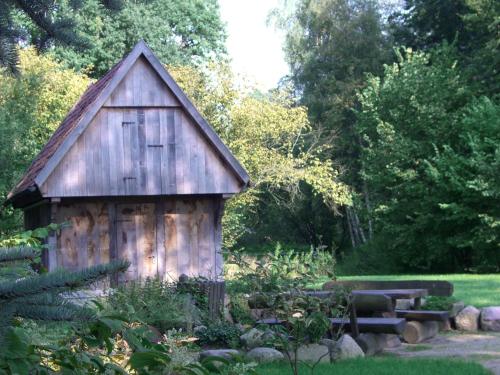 a wooden shed with a bench in a garden at Hotel Ehlers in Schneverdingen