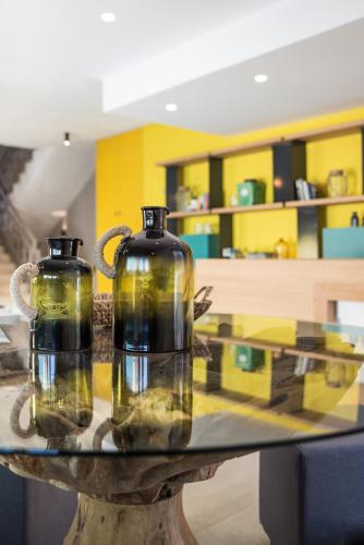 two glass bottles sitting on a table in a room at Sunshine Boutique Hotel by Estia in Malia