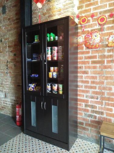 a black cabinet with food in it next to a brick wall at JQ Ban Loong Boutique Hotel in Ipoh