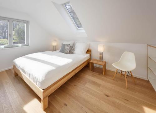 - une chambre blanche avec un lit et une chaise dans l'établissement Ferienhaus Lillesol, à Breege
