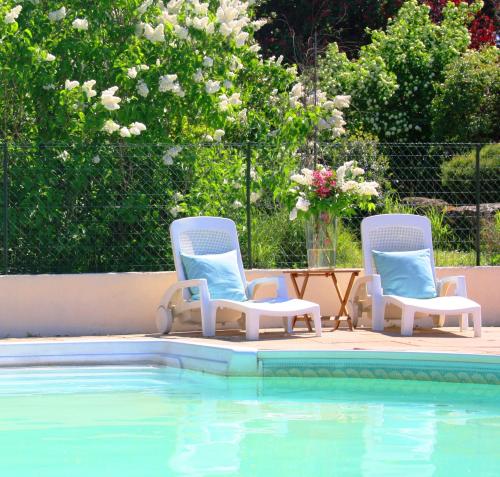 two chairs and a table next to a swimming pool at Domaine Charente - Holiday Home with own garden in Mazières