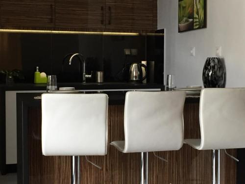 une cuisine avec des chaises blanches et un comptoir de cuisine dans l'établissement Athens Penthouse Cosy Apartment, à Athènes