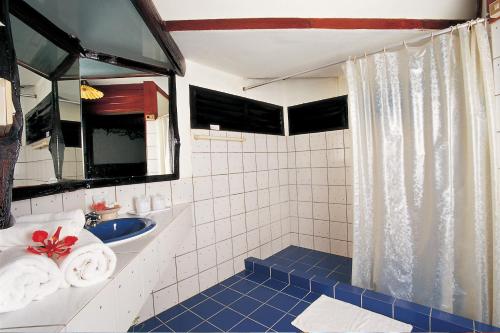 La salle de bains est pourvue d'un lavabo et d'une douche avec du carrelage bleu. dans l'établissement Pung-Waan Resort, à Sai Yok