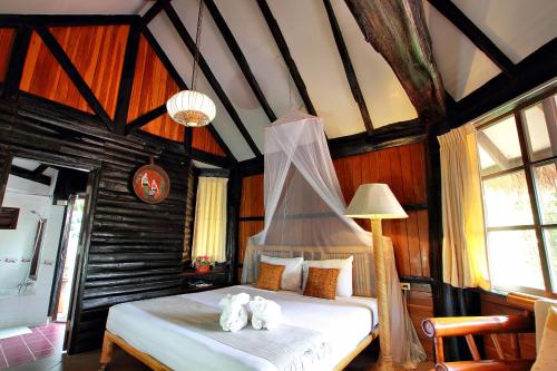 a bedroom with a bed with towels on it at Pung-Waan Resort in Sai Yok