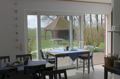 a dining room with a table and a gazebo at Apartmenthaus Seestern in Neßmersiel