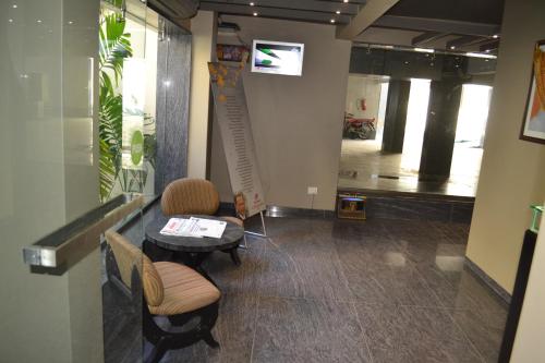 ein Zimmer mit 2 Stühlen und einem Tisch in einem Gebäude in der Unterkunft Hotel Sonia CIDCO in Aurangabad