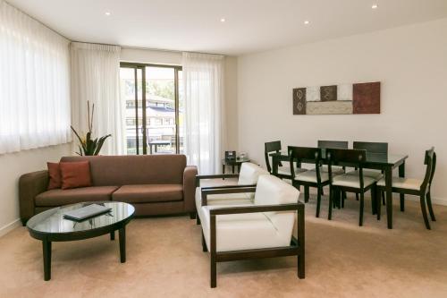 a living room with a couch and a table at Grand Mercure Allegra Hervey Bay in Hervey Bay