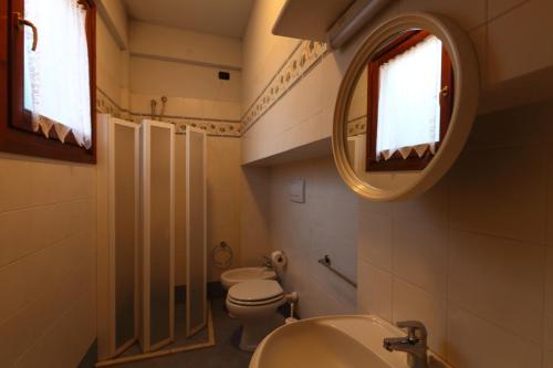 bagno con 2 servizi igienici, lavandino e specchio di Casale del Vacanziere a Certaldo