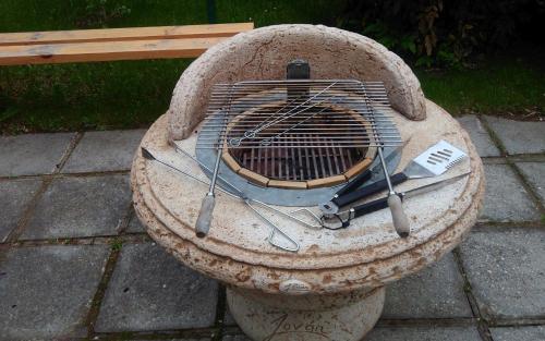 a stone grill sitting on the ground next to a bench at Ciszterci Szállás Pécs in Pécs