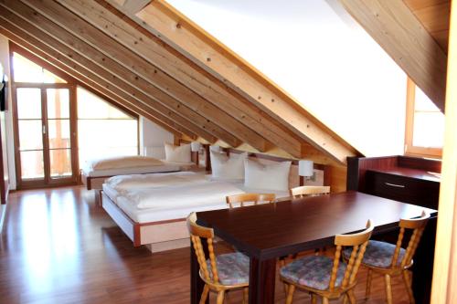 1 dormitorio con 1 cama, mesa y sillas en Hotel-Gasthof Kramerwirt, en Irschenberg