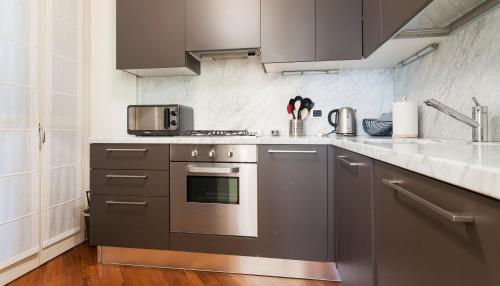 a kitchen with stainless steel appliances and gray cabinets at Italianway-Brisa in Milan