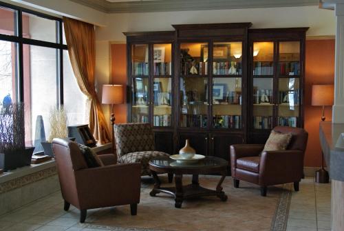 a living room with chairs and a table and a bookcase at Maritime Inn Antigonish in Antigonish