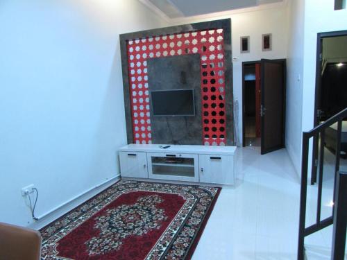 a living room with a television and a rug at Villa Zam Zam Syariah in Puncak
