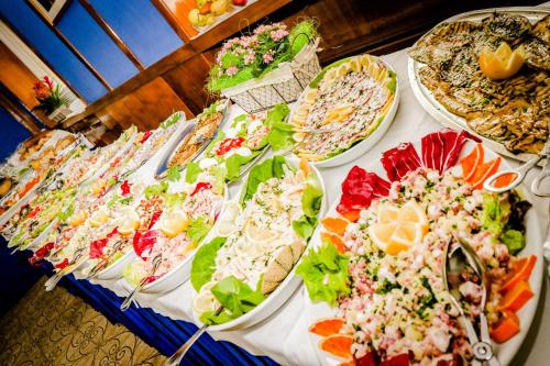 a table with many plates of food on it at Hotel Cristallo in Riolo Terme