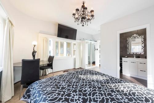 a white bedroom with a black and white bed and a desk at Jones On Wilson Boutique B&B in Burnie